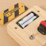 Close-up of PowerBoard battery compartment — wooden LED busy board Parent Nest